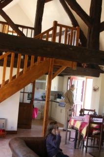 Vue de l'intérieur du gîte « Le Débucher », murs blancs et poutres apparentes.